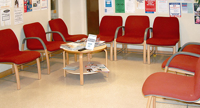 A clinic waiting room with a number of empty chairs