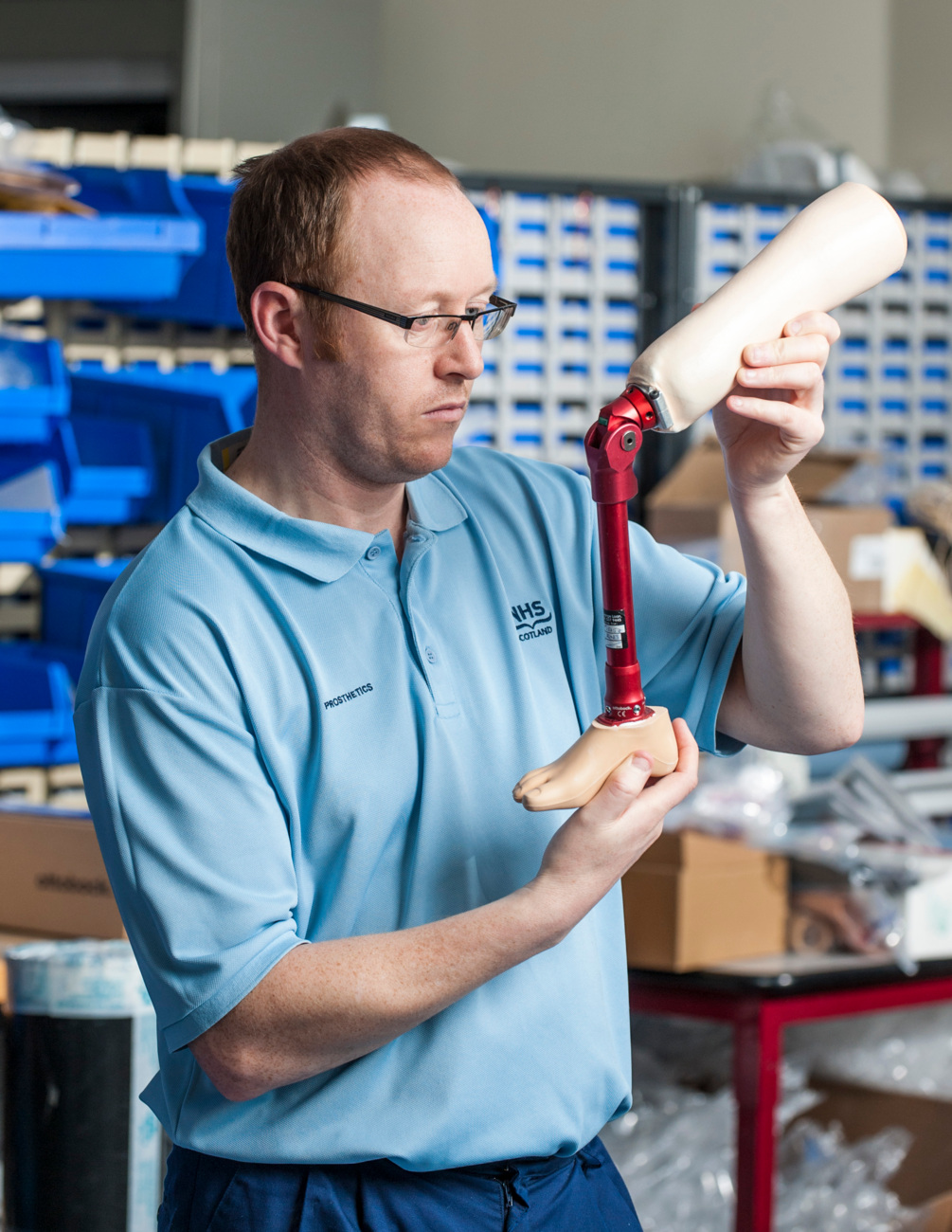 NHS prosthetist examining a child's artificial leg